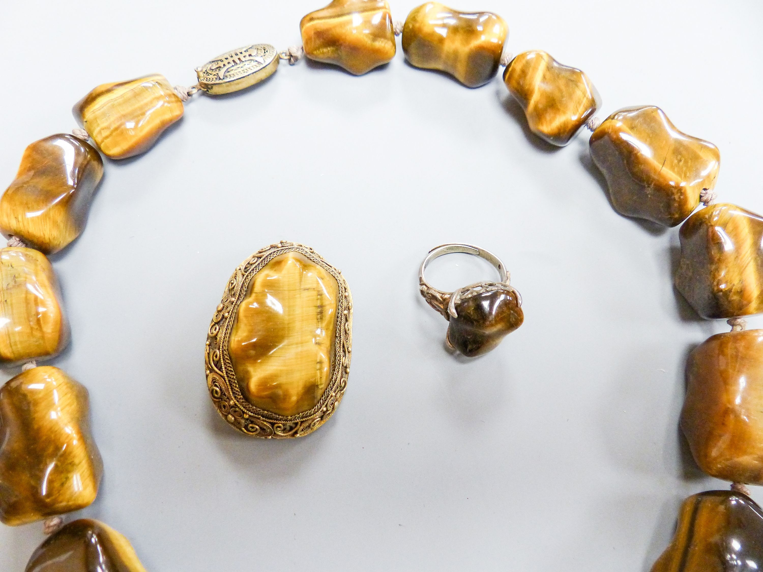A Middle Eastern gilt white metal and tiger's eye pebble necklace, 48cm and a similar brooch and - Image 2 of 4