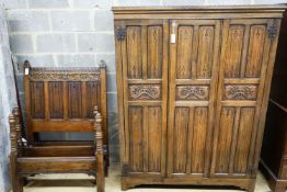 A 17th century style carved and panelled oak triple wardrobe with linenfold decoration, and a pair