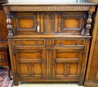 A 17th century style carved and panelled oak court cupboard,on turned supports, length 145cm,