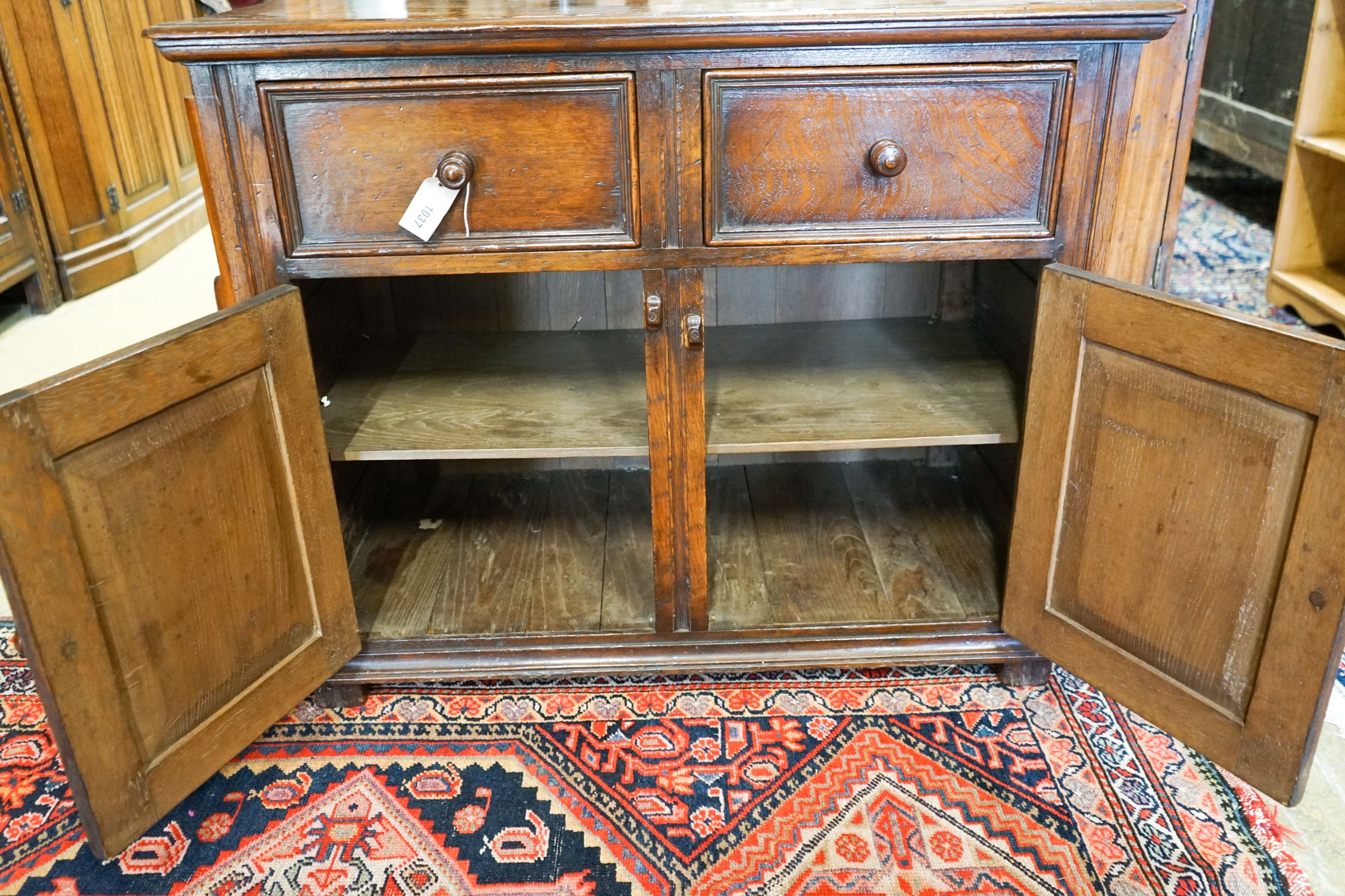 A 17th century style carved and panelled oak cupboard,fitted two drawers and two cupboards, width - Image 3 of 4