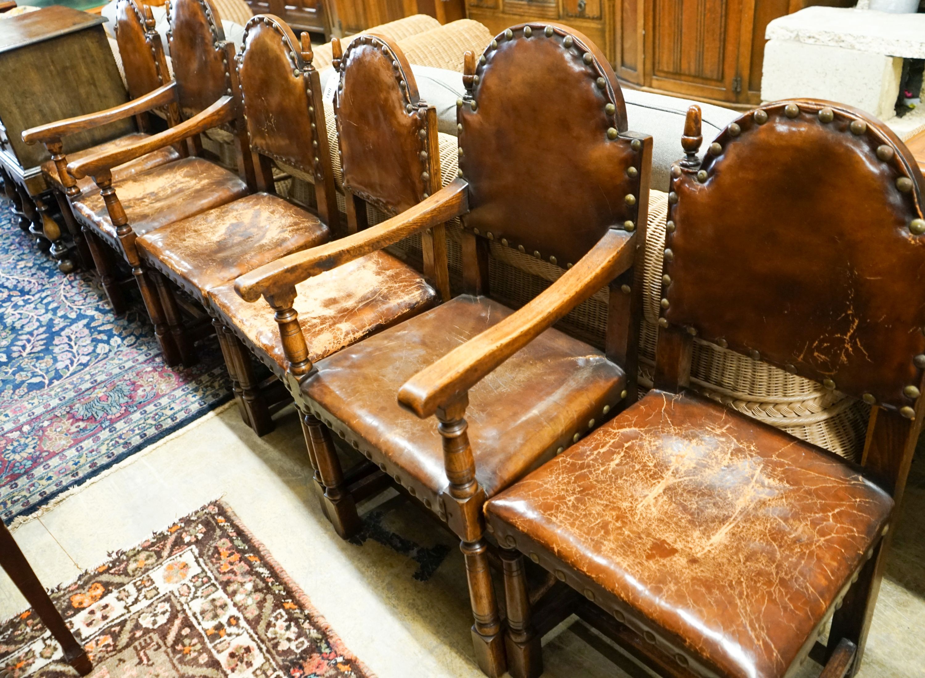 A set of six oak dining chairs,having arched backs and brass-studded brown leather upholstery (two