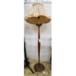 A turned and carved walnut standard lamp on circular base with bun feet, height excluding shade