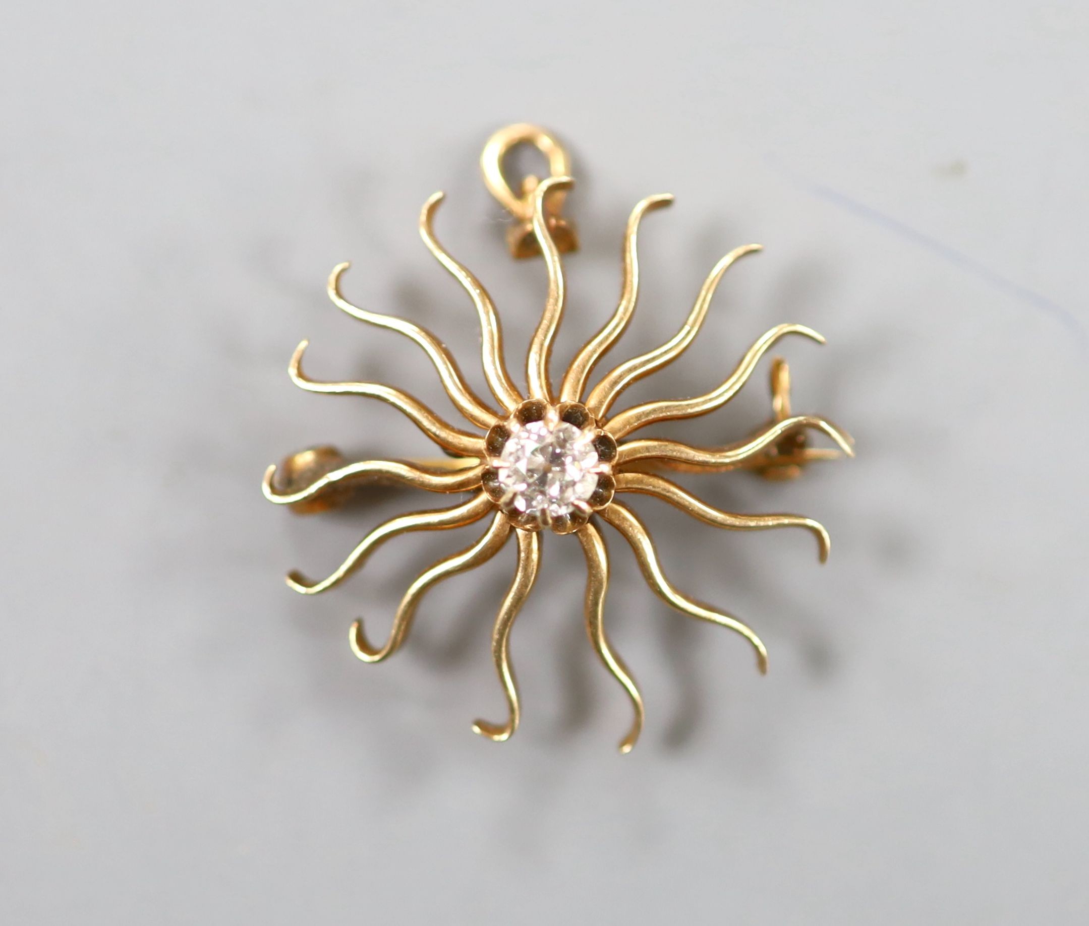 A yellow metal and single stone diamond set sun burst pendant brooch, 25mm, gross weight 4.7 grams,