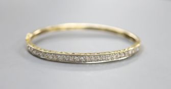 A modern 585 yellow metal and diamond chip set hinged bangle, interior diameter 62mm,gross weight