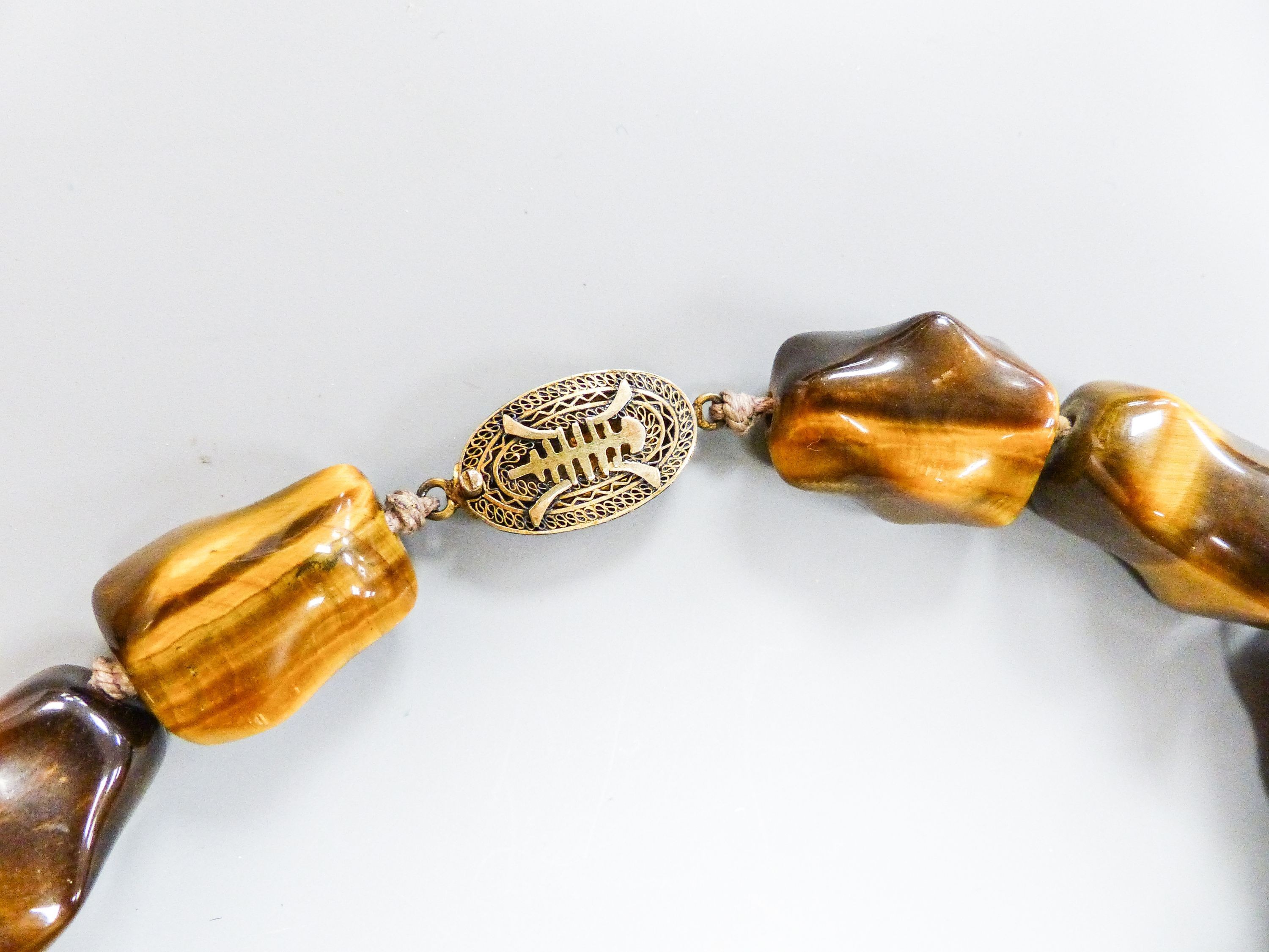 A Middle Eastern gilt white metal and tiger's eye pebble necklace, 48cm and a similar brooch and - Image 3 of 4