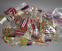 A large collection of unnamed WWII medals and spare ribbons and a cased QEII Imperial Service