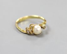 An 18k, single stone cultured pearl and two stone diamond chip set ring, size J, gross 1.9 grams.