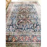 A Tabriz/Meshed blue ground carpet,the central field decorated with trailing flowers and leaves