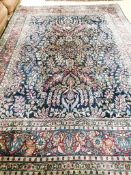 A Tabriz/Meshed blue ground carpet,the central field decorated with trailing flowers and leaves