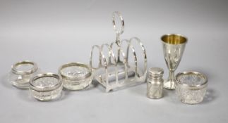 A silver toastrack, four silver mounted glass jars, a small silver goblet, and a Victorian silver