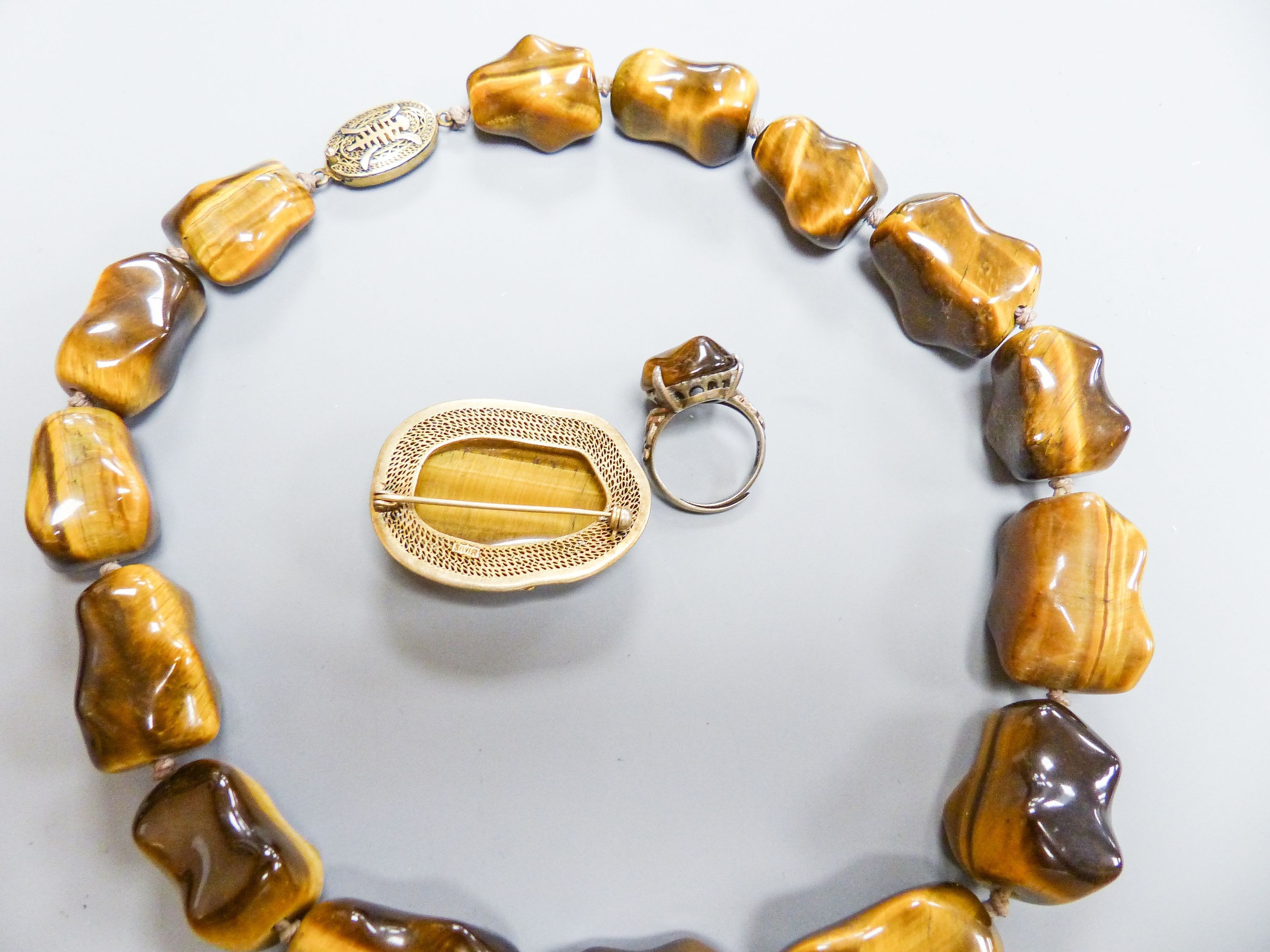 A Middle Eastern gilt white metal and tiger's eye pebble necklace, 48cm and a similar brooch and - Image 4 of 4