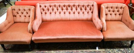 A late Victorian three piece lounge suite, upholstered in pink dralon, settee length 140cm, depth