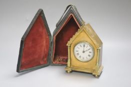 A late 19th century French Gothic brass cased carriage timepiece, with felt-lined carrying case,