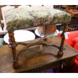 A William and Mary style walnut stool, having embroidery-covered seat on turned supports with