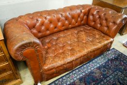 A late Victorian drop arm leather button back Chesterfield settee, length 170cm, depth 88cm,