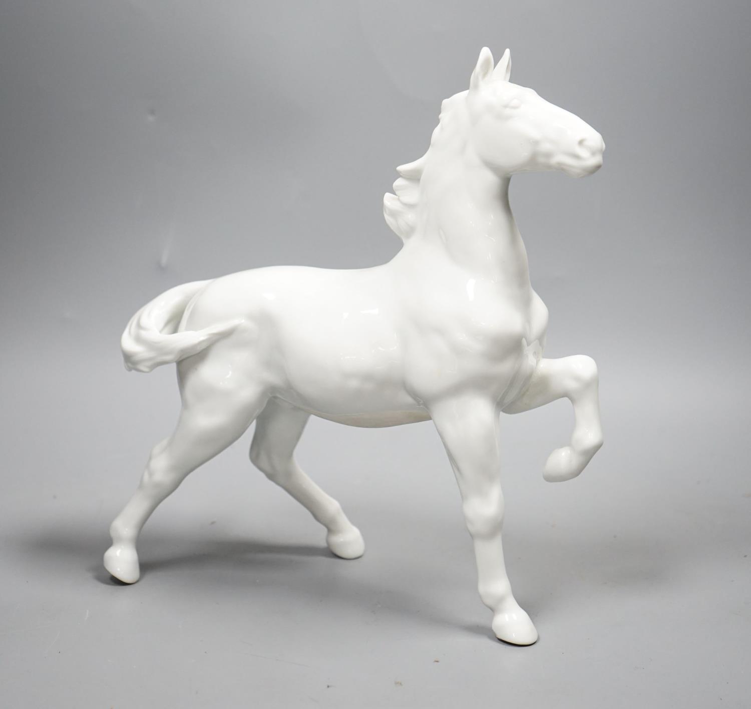 A Japanese porcelain figure of a horse, a Chinese blue and white dish, a Southeast Asian metal