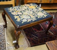 A George III style mahogany stool with drop in tapestry seat on ball and claw feet, signed JS