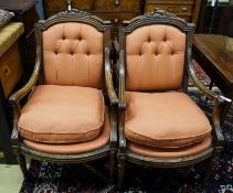 A set of four 19th century French carved walnut elbow chairs with buttoned fabric upholstery,