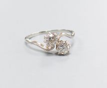 A white metal and two stone diamond set crossover ring, size K, gross 2.4 grams,each stone