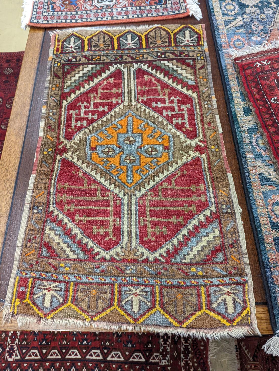 A Caucasian red ground mat, a Bokhara mat, three others and a blue ground rug, largest 136 x 80cm ( - Image 3 of 7