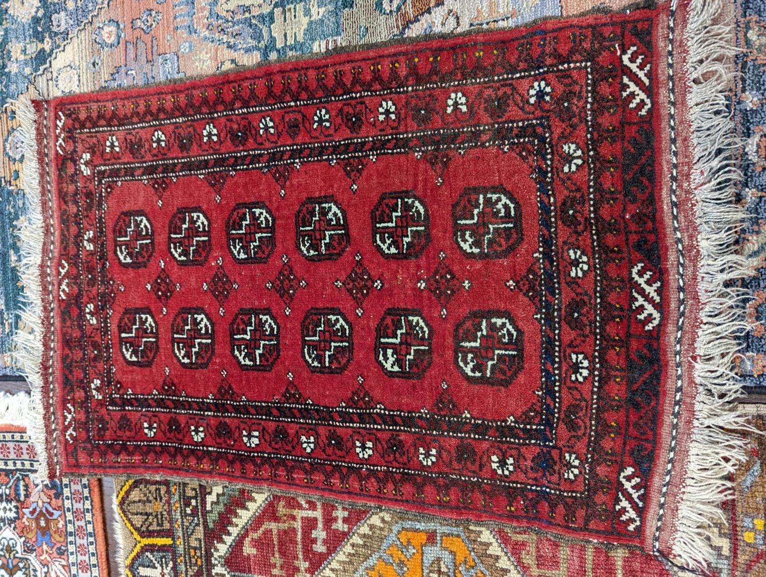 A Caucasian red ground mat, a Bokhara mat, three others and a blue ground rug, largest 136 x 80cm ( - Image 2 of 7