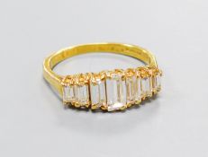 A modern 18ct gold and graduated seven stone baguette cut diamond set half hoop ring, size O,