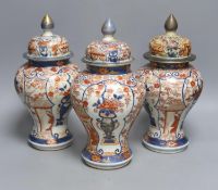 Three 18th century Japanese Arita baluster vases and covers decorated with flowers in urns (damage