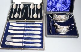 A cased Edwardian silver cream, sugar and sugar tongs, Birmingham, 1901 and two other cased sets