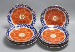 A set of eight Chinese plates with orange 'lotus' centres and blue floral borders, Qing dynasty,