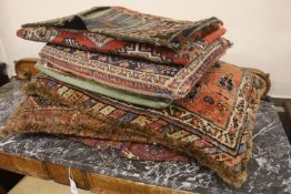 Three Bokhara rugs, four kilim-faced cushions and a small saddlebag, largest 74 x 50cm