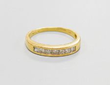 A modern 18ct gold and channel set seven stone diamond half hoop ring, size P, gross weight 2.8