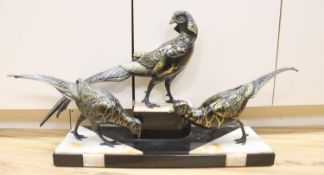 An Art Deco cold painted and gilded spelter model of 3 pheasants on a black and rouge marble base,