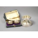 A German white metal dwarf candlestick and a cased pair of silver napkin rings by Walker & Hall.