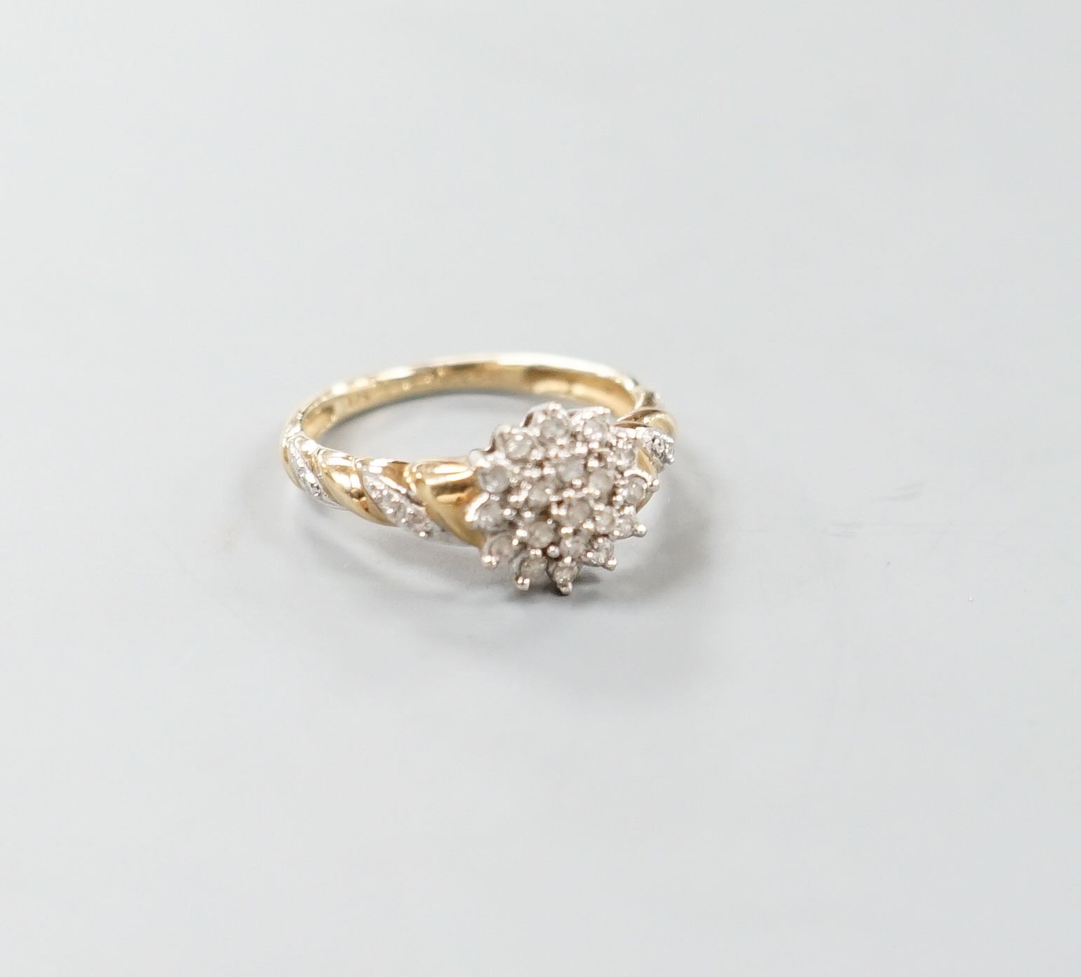 A modern 9ct gold and diamond cluster ring, with diamond chip set shoulders, size P, gross weight