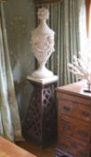 A pair of white painted carved walnut urns and covers, on wrought iron stands, the urns carved