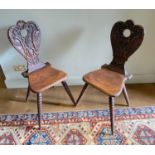 A pair of 19th century Swiss carved oak hall chairs, with vine and scroll backs and tapered bobbin