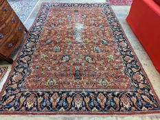 A Persian style machined brick red ground carpet (severely worn), 392 x 286cm