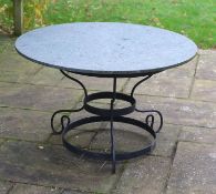 A wrought iron garden table with circular green marble top, width 123cm height 75cm