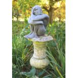 A simulated lead resin garden statue of a seated man, height 49cm, with a damaged marble pedestal,