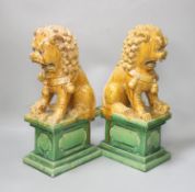 A pair of Chinese Ming style sancai-glazed pottery temple lions,on stepped rectangular bases,H 35cm