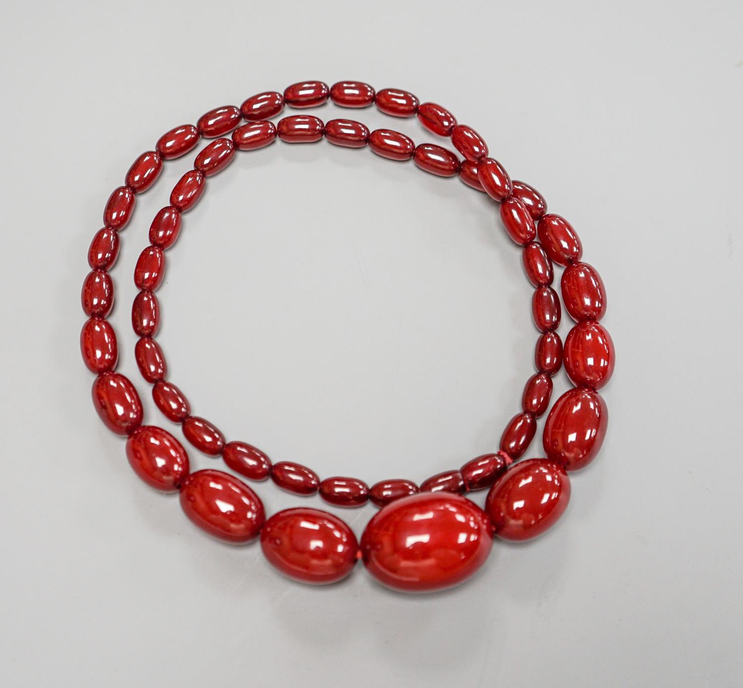 A single strand graduated simulated cherry amber bead necklece, 72cm, gross weight 63 grams. - Image 2 of 2