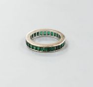 A white metal and green garnet? set full eternity ring, size L, gross weight 3.3 grams.