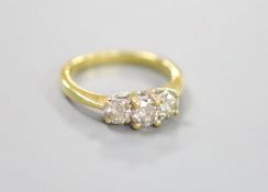 A modern 18ct gold and three stone diamond ring, size M, gross weight 3.4 grams.