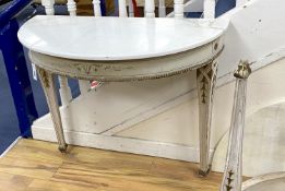 A pair of French marble topped demi lune console tables, with later veined white marble tops and