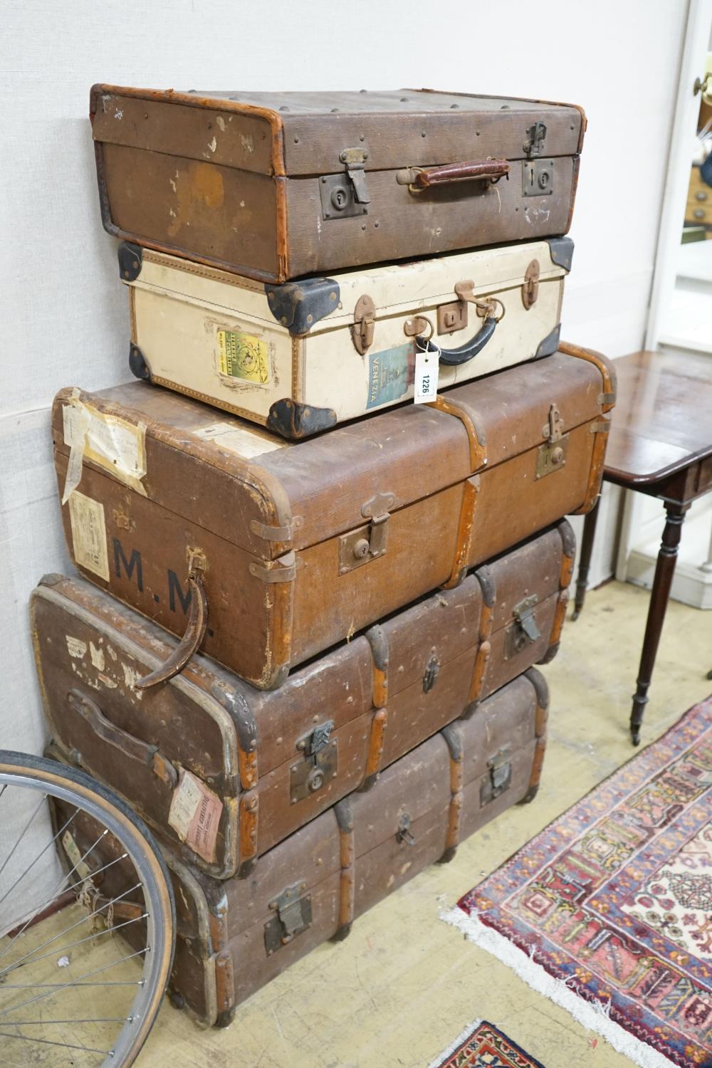A collection of five vintage suitcases, largest width 83cm