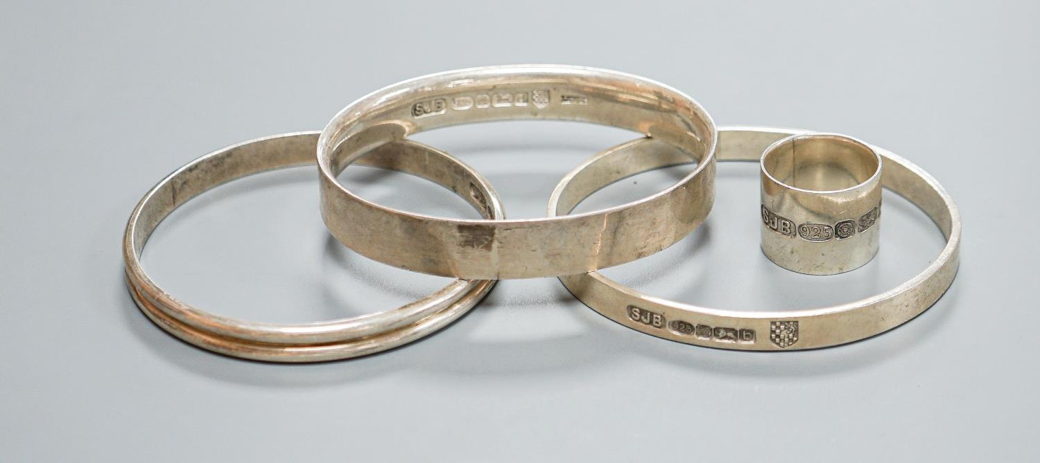 Three modern silver bangles and a large silver band, all by Simon J. Beer of Lewes,191 grams, ring
