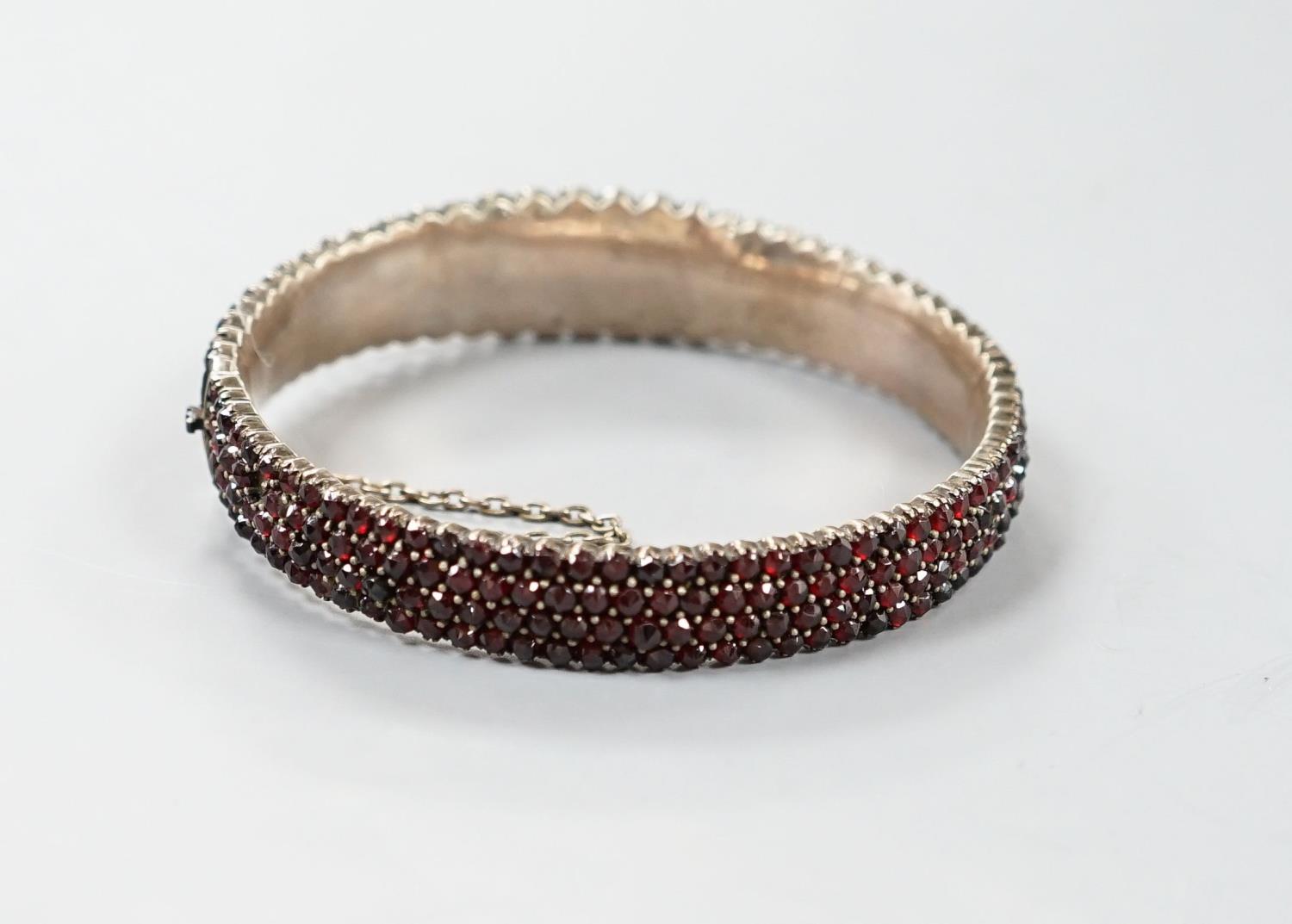 A late Victorian gilt white metal and garnet encrusted hinged bangle (stone missing). - Image 3 of 4