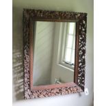 A Continental hardwood wall mirror, carved and pierced with squirrels and fruit, width 77cm height