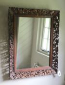 A Continental hardwood wall mirror, carved and pierced with squirrels and fruit, width 77cm height