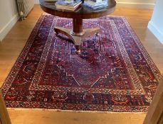 A Caucasian red ground carpet, decorated with foliate motifs, multi-bordered and signed in one